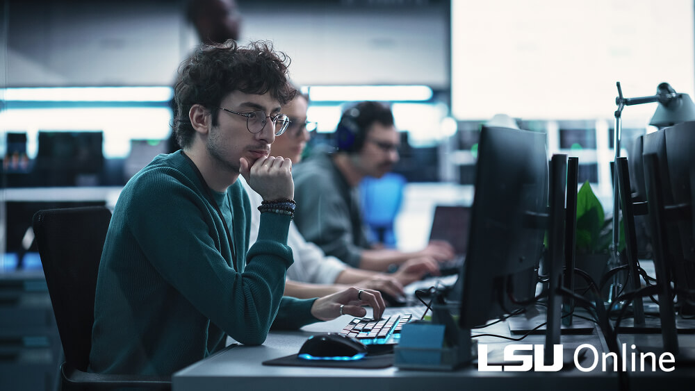 Team of three working at a computer in a modern office